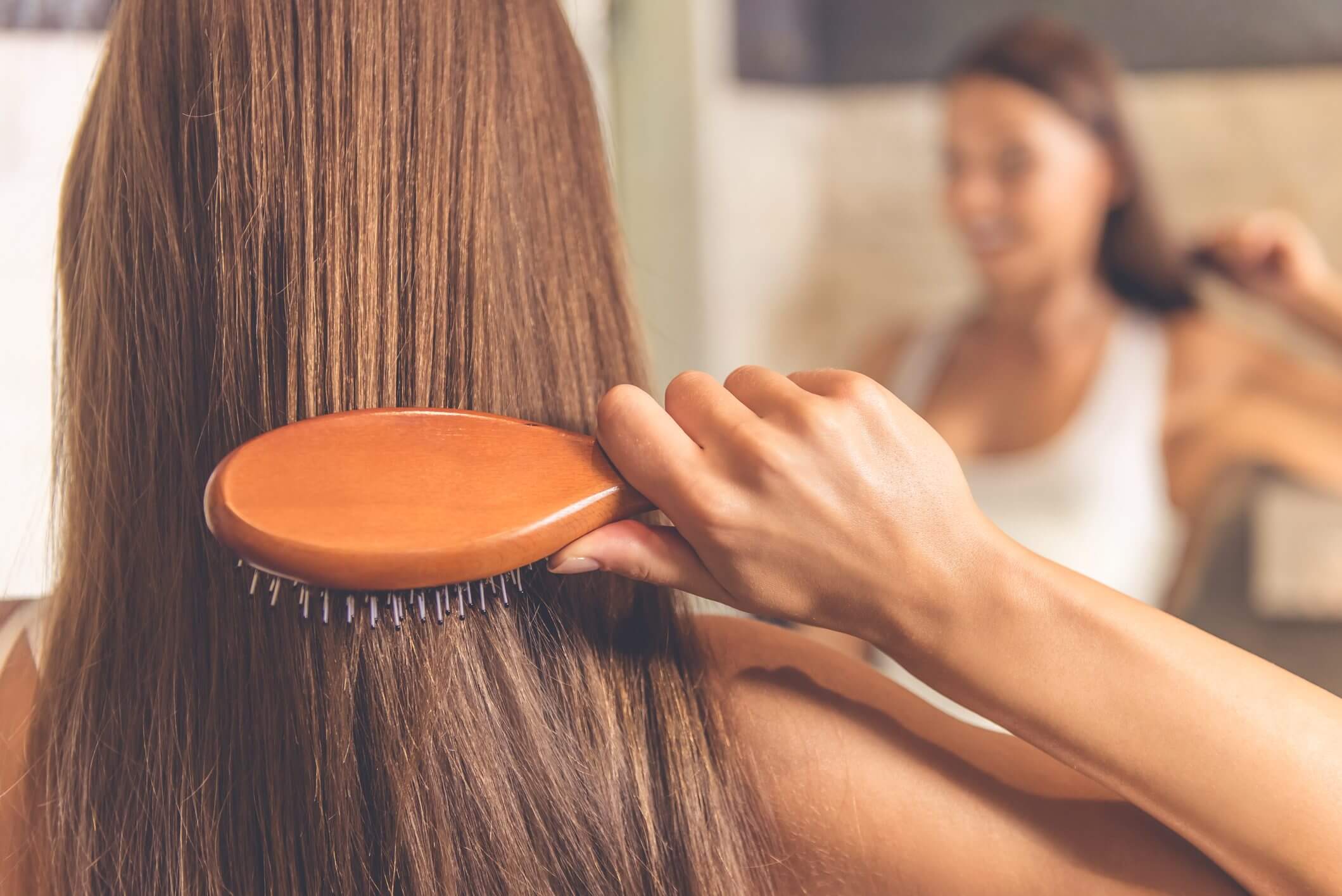 Person applying natural hair growth treatment at home using oils and masks