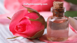 Pure rose water in a glass bottle with fresh rose petals for skincare hydration and anti-aging benefits.