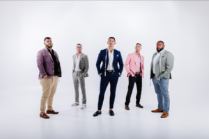 A confident individual smiling while dressed comfortably in their unique personal style, feeling a sense of belonging among a group of friends.